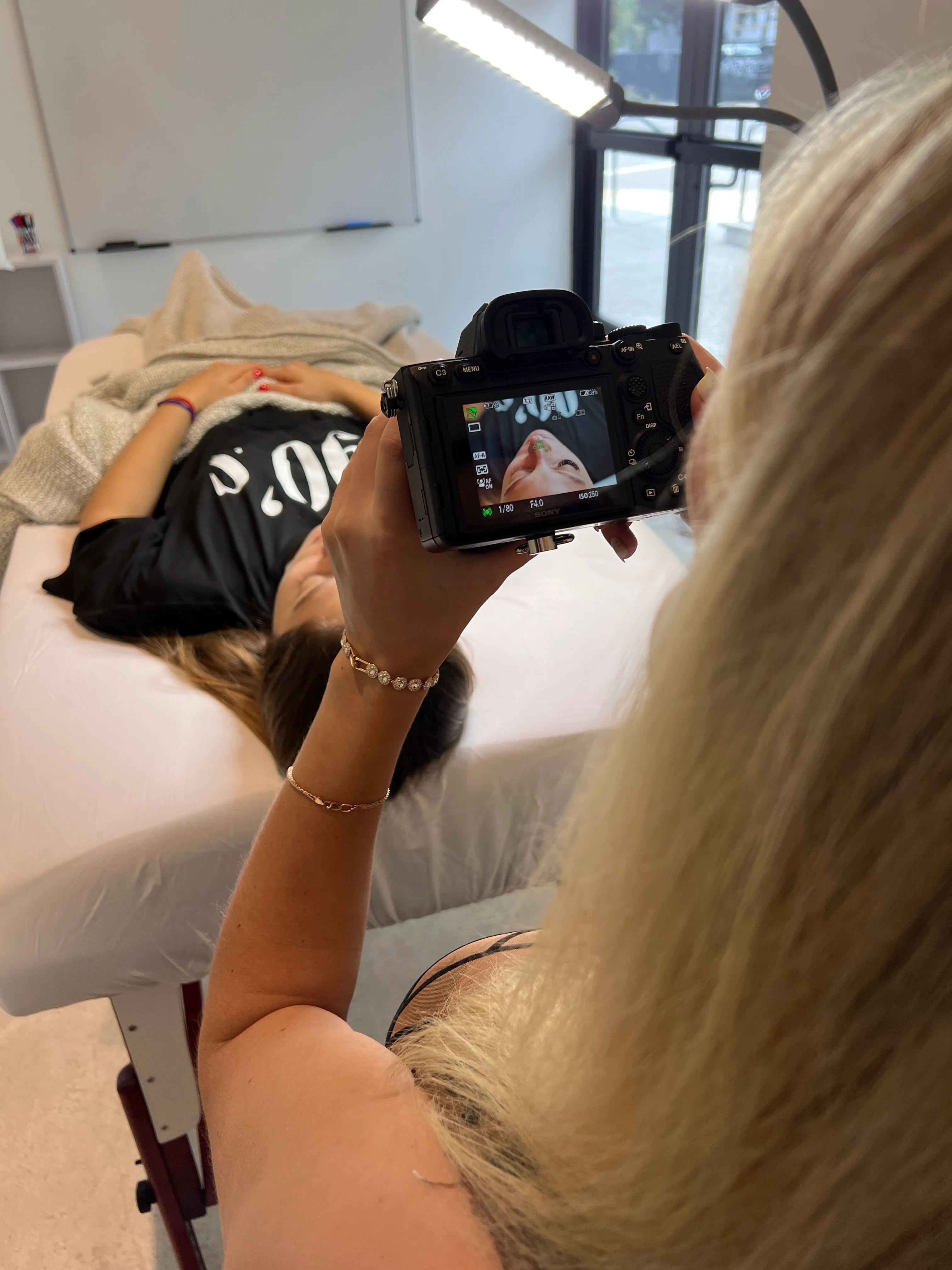 Anastasiia fotografiando el nuevo juego de pestañas de una clienta en el estudio de Eye Charm en Hyde Park, Austin